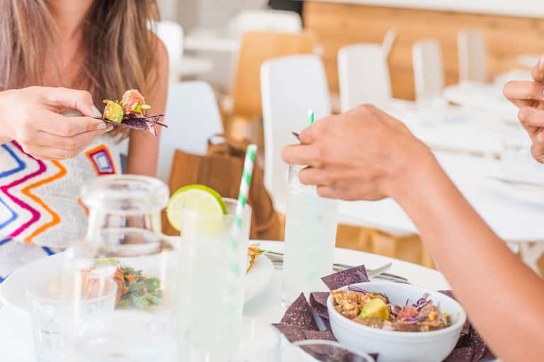 Fine dining table with colorful plated dishes and refreshing beverages during meal service