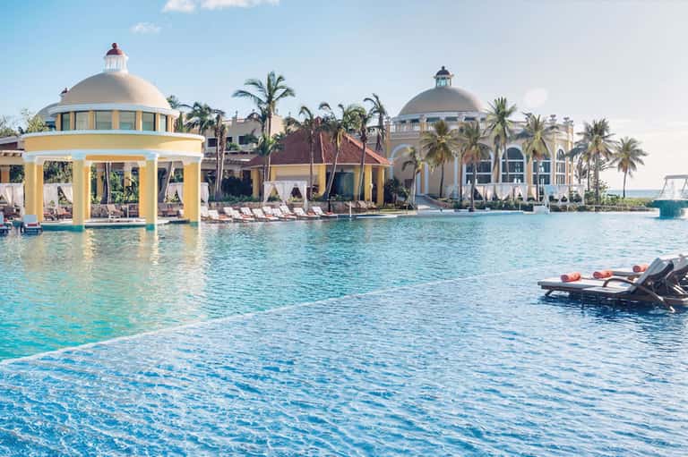 Luxury tropical resort with yellow gazebo, lagoon pools, palm trees, and ornate architecture