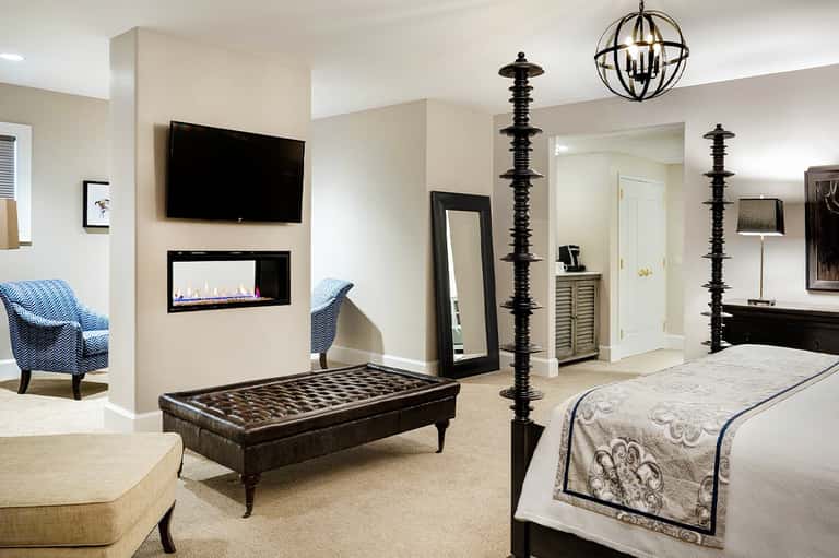 Luxury hotel suite with fireplace, TV, pool table, and modern furnishings