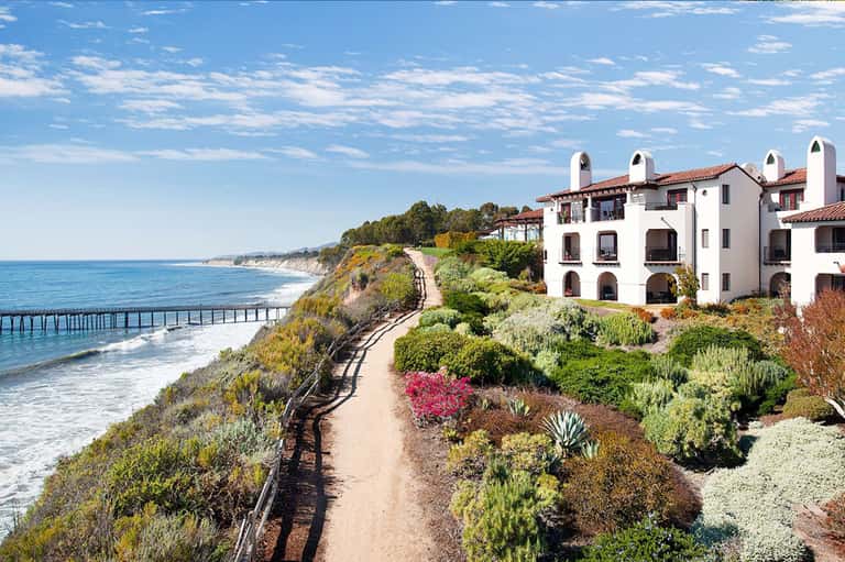 Cliffside Spanish-style resort building with ocean and beach views, coastal landscape