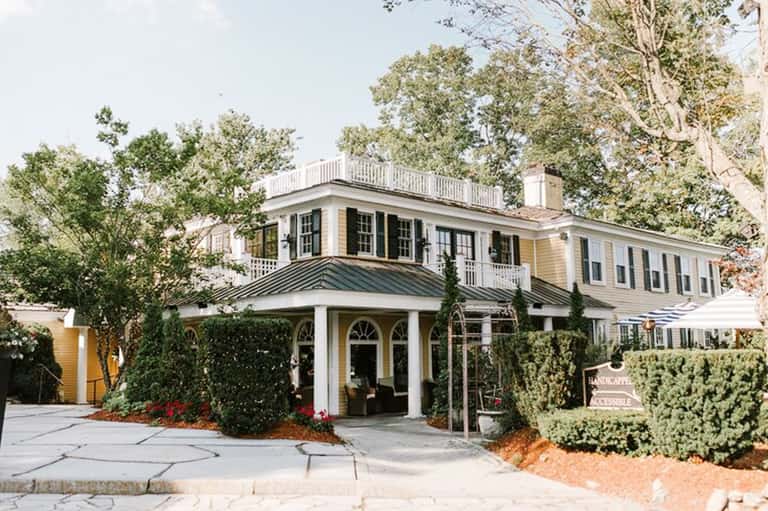 Colonial-style beachfront house with white columns and wraparound porch