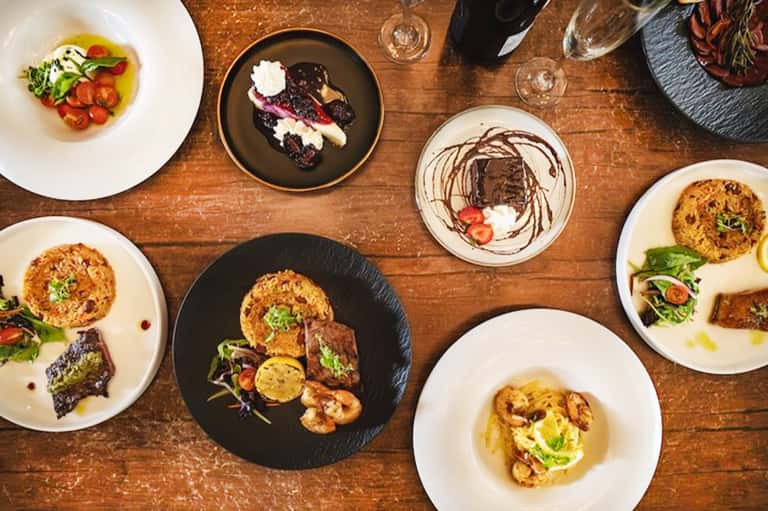 Fine dining table with multiple gourmet plates featuring seafood and creative plating