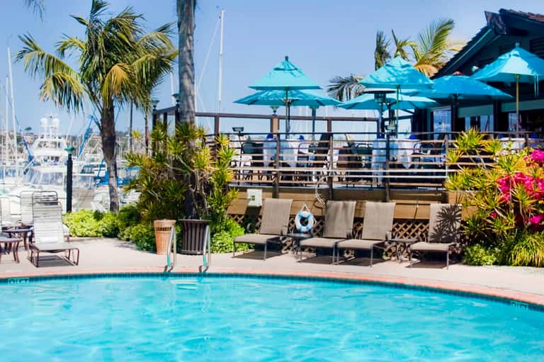 Waterfront pool with turquoise umbrellas and marina views