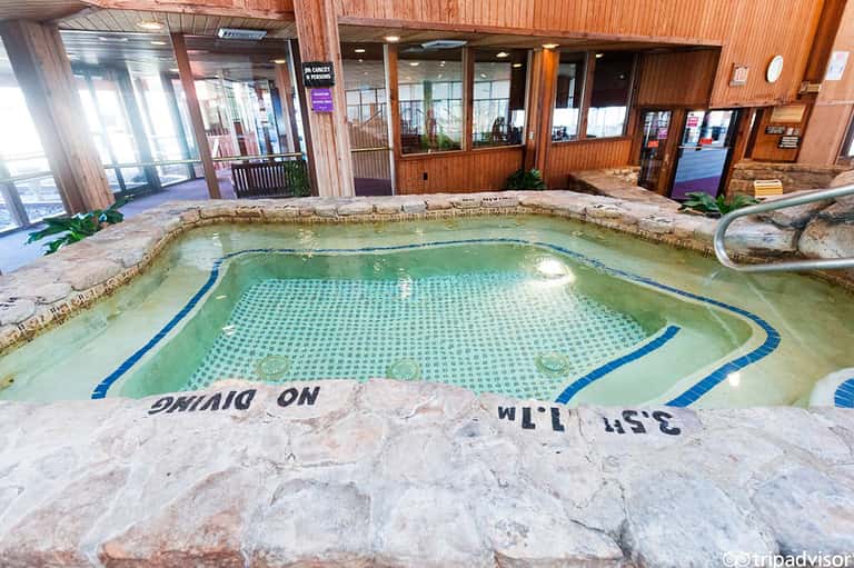 Indoor heated swimming pool with tiled floor and wooden walls