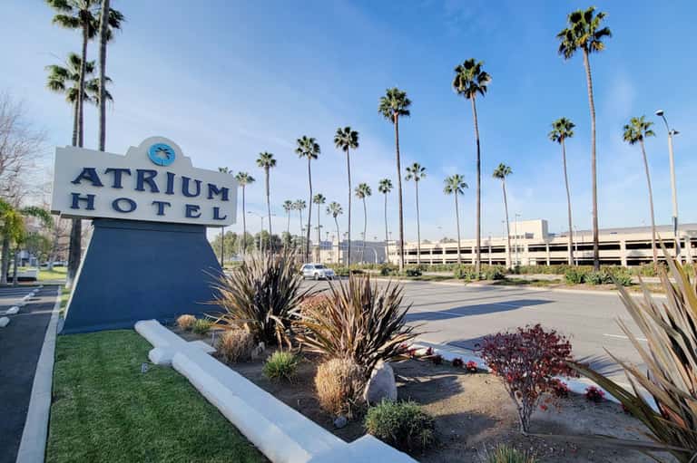 Atrium Hotel sign with tall palm trees and modern building architecture