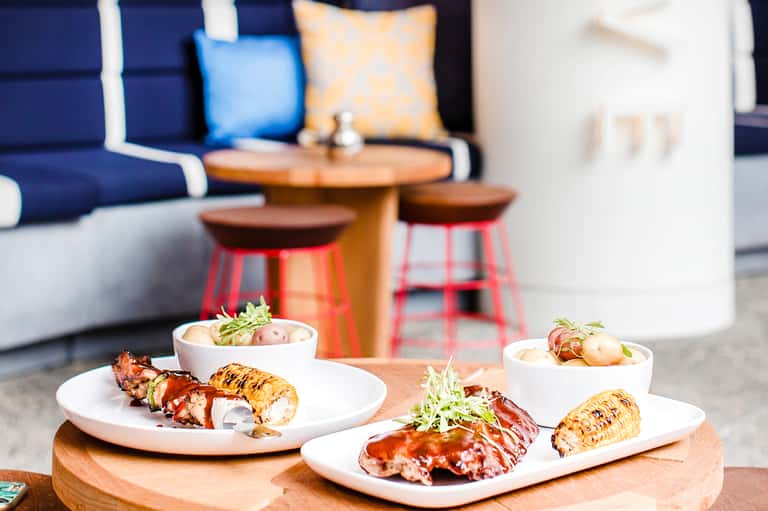 Grilled lobster tails plated elegantly with sides in upscale outdoor dining area