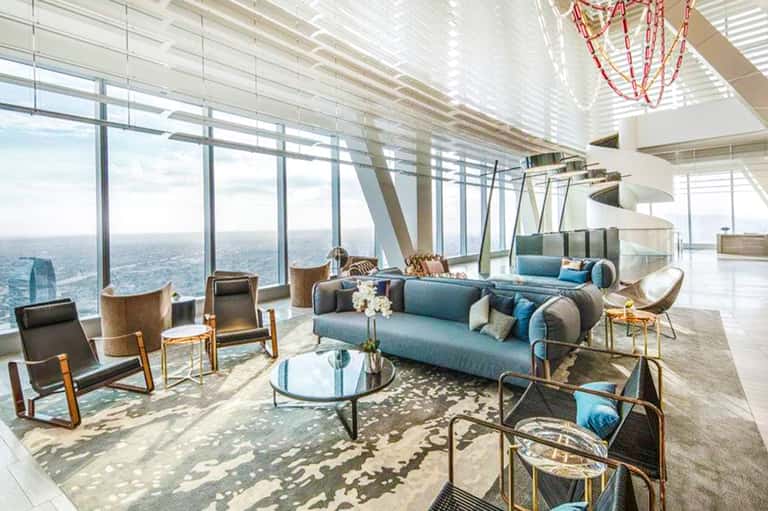 Luxury high-rise lounge with panoramic ocean views, modern furniture, and floor-to-ceiling windows