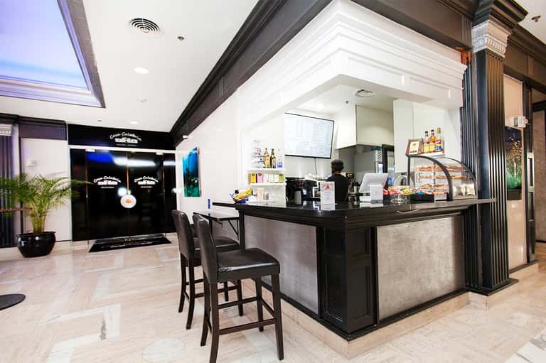 Modern hotel lobby bar with black counter, white ceiling, and contemporary interior design