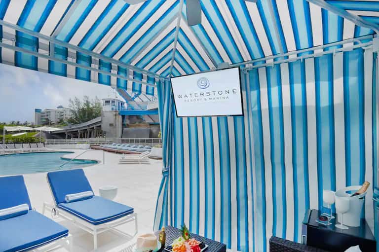 Waterstone Resort & Marina pool area with blue and white striped cabana tent and lounge chairs