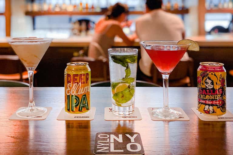 Bar counter displaying craft beers and cocktails with ocean view in background