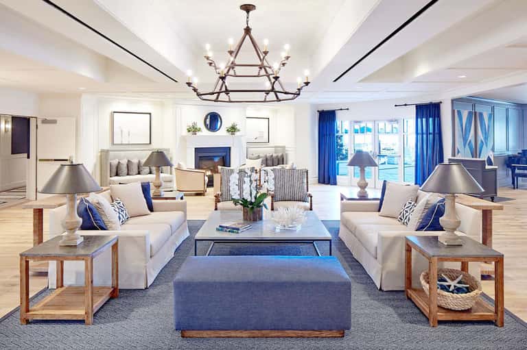 Elegant hotel living room with blue accents, fireplace, and ocean view doors