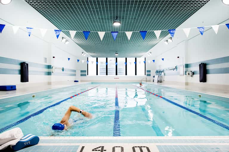 Indoor Olympic-size swimming pool with lane dividers and blue bunting decoration