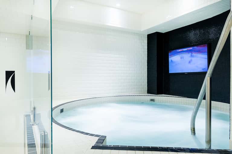Modern circular hot tub spa with white and black tile interior