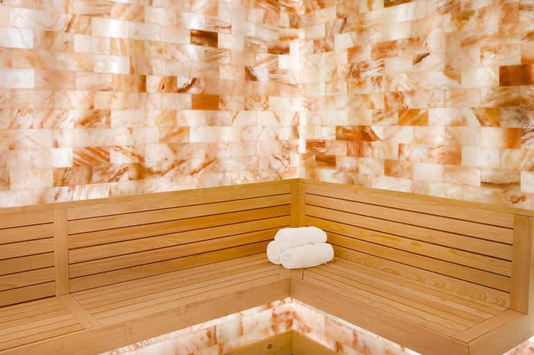 Spa sauna interior with salt block walls and wooden bench seating