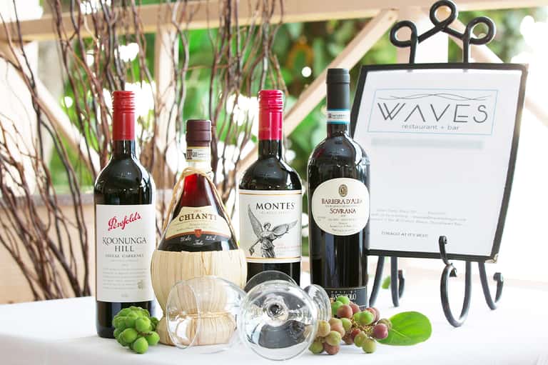 Wine bottles and glasses displayed with wine list sign at upscale resort restaurant bar