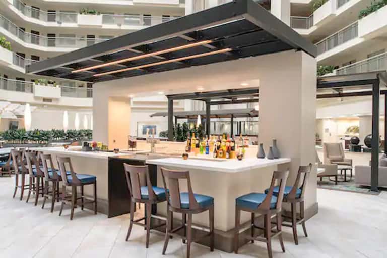 Contemporary bar counter with seating and amber beverage bottles under black canopy