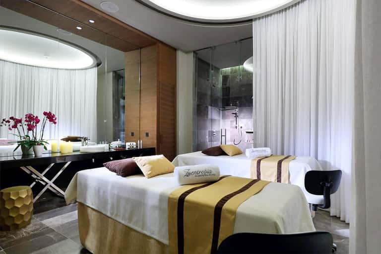 Luxury hotel bedroom with gold accents, modern furnishings, and spa-like bathroom