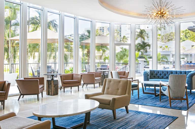 Contemporary lobby lounge with floor-to-ceiling windows overlooking resort grounds