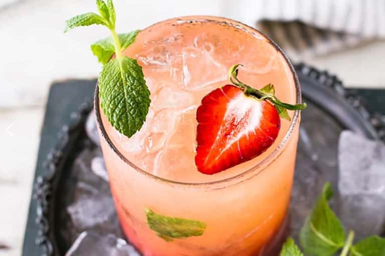 Refreshing strawberry and mint cocktail with ice served in crystal glass