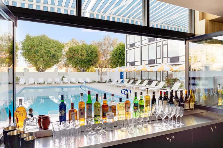 Modern bar with full liquor selection overlooking indoor pool and resort grounds