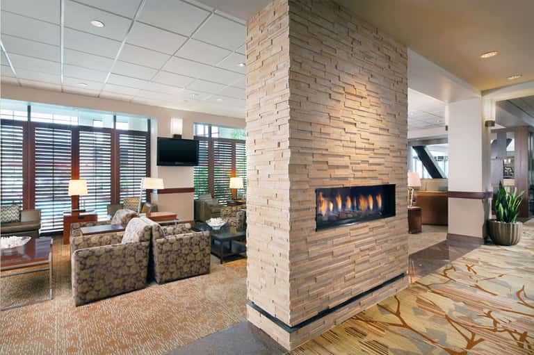 Upscale lobby lounge with fireplace, comfortable seating, and decorative elements