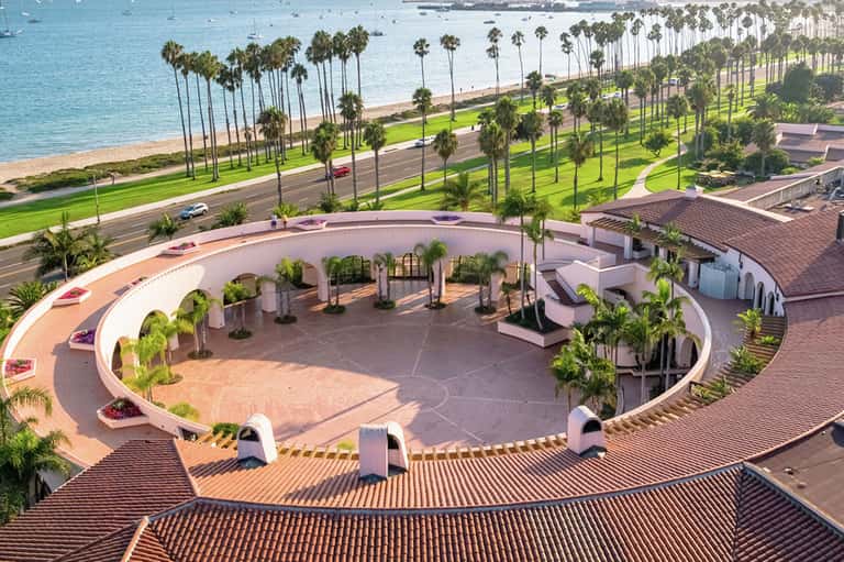 Aerial view of circular plaza with palm trees overlooking California beach and coastline