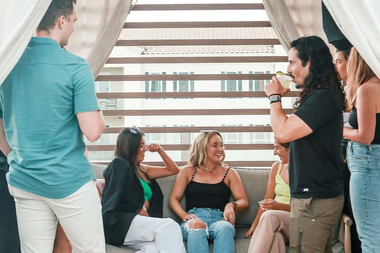 Group of people socializing on modern stairs with ocean views in background