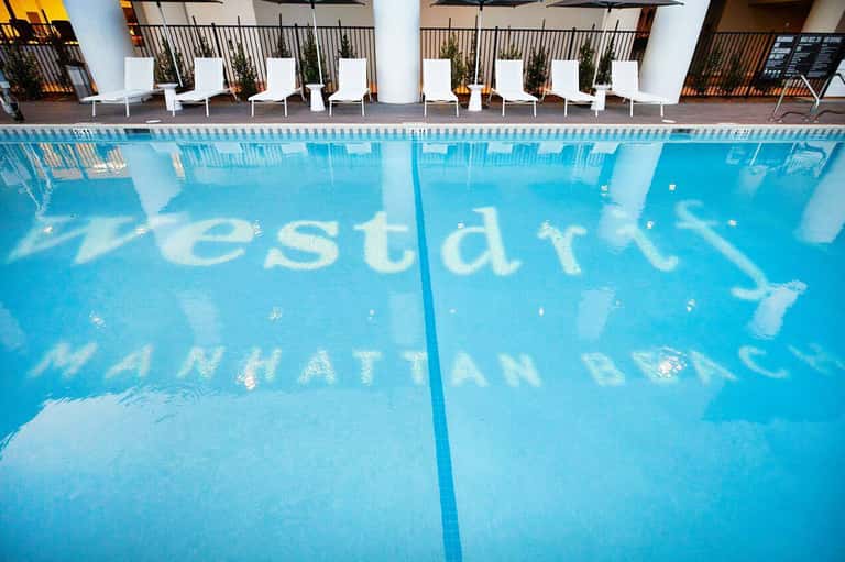 Olympic-sized lap pool with lane dividers and white lounge chairs lining the deck
