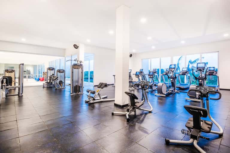 Modern fitness center with exercise bikes and cardio equipment overlooking ocean view