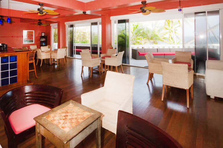 Lounge area with red ceiling, orange walls, and casual seating near windows