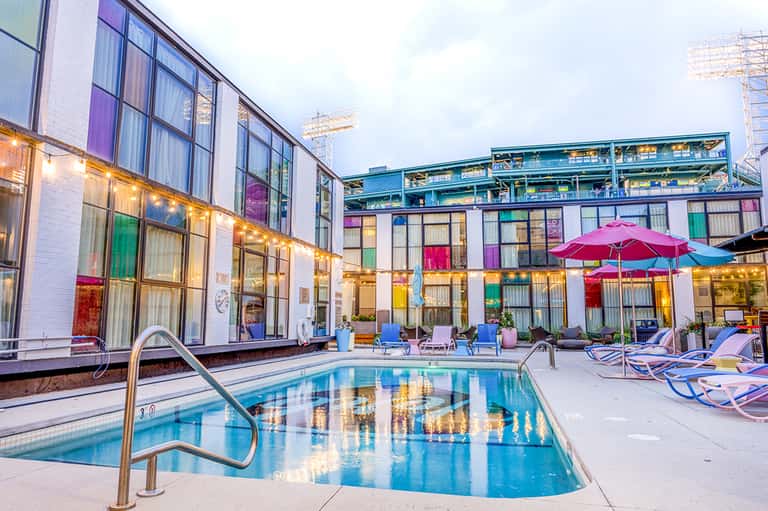 Contemporary hotel pool with colorful building facade and umbrellas