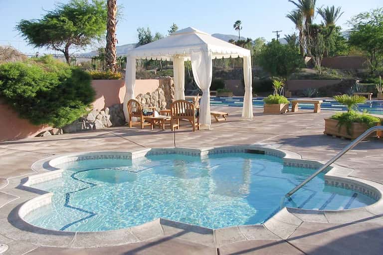 Desert spa resort with hot tub, white gazebo, pool, and dramatic pyramid structure