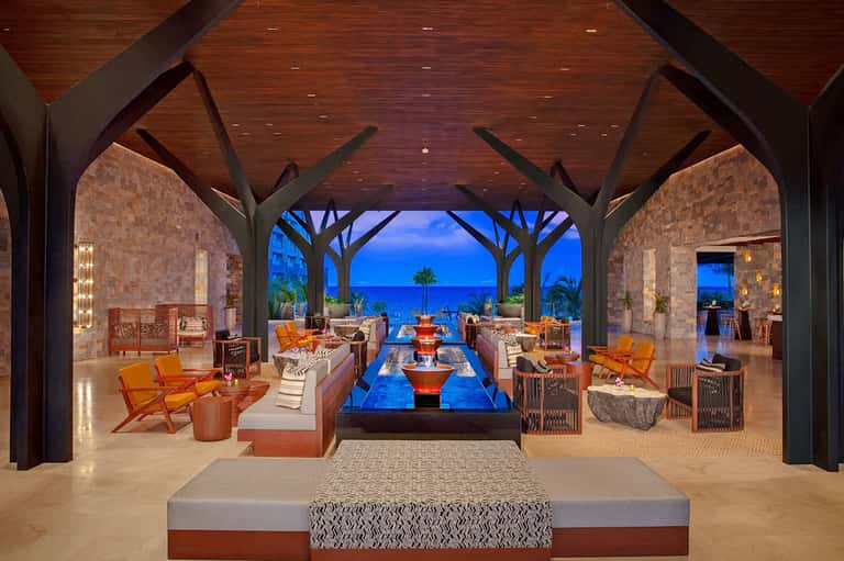 Luxurious beachfront lounge with fireplace, ocean views, and modern architectural design