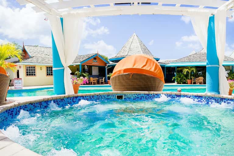 Spa hot tub with whirlpool jets under white pergola canopy overlooking pool area