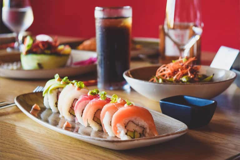 Fine dining sushi platter with cocktails and Japanese cuisine on wooden table