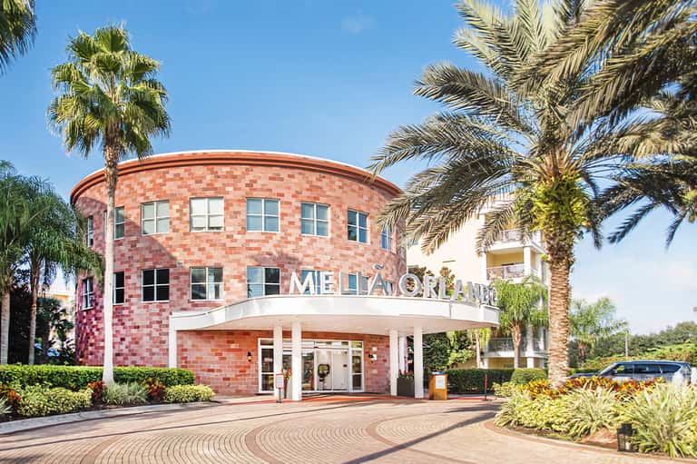 Distinctive red brick circular hotel entrance with palm trees and modern architectural design