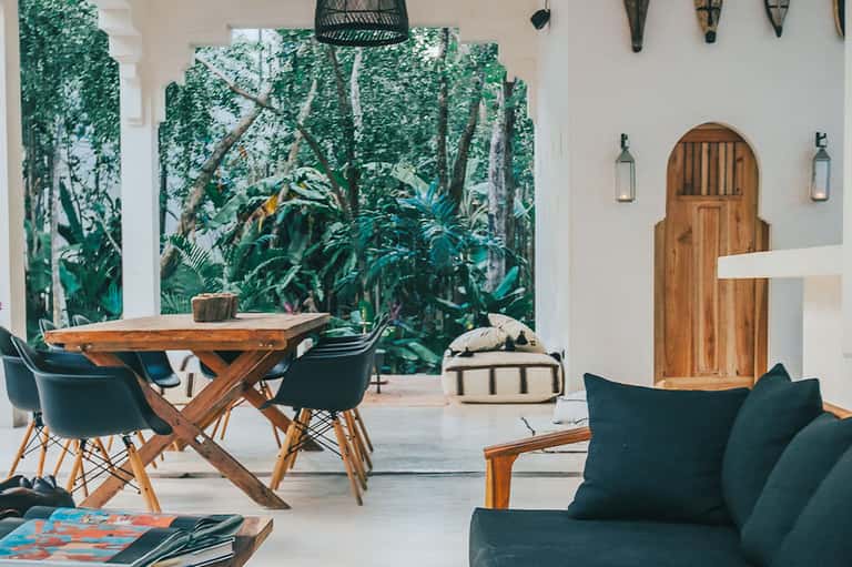 Modern lounge area with jungle mural, wooden table, and teal seating