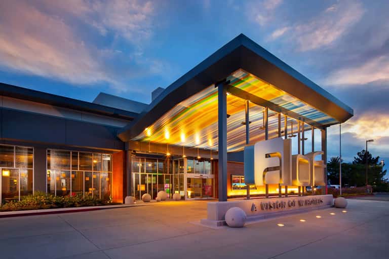 Modern resort entrance with illuminated canopy at dusk and contemporary architecture
