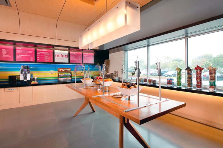 Modern juice bar and café interior with colorful menu boards and waterfront views through windows