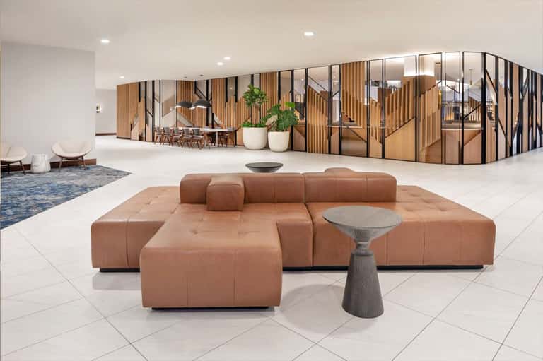 Modern hotel lobby with brown leather seating and wood partition walls