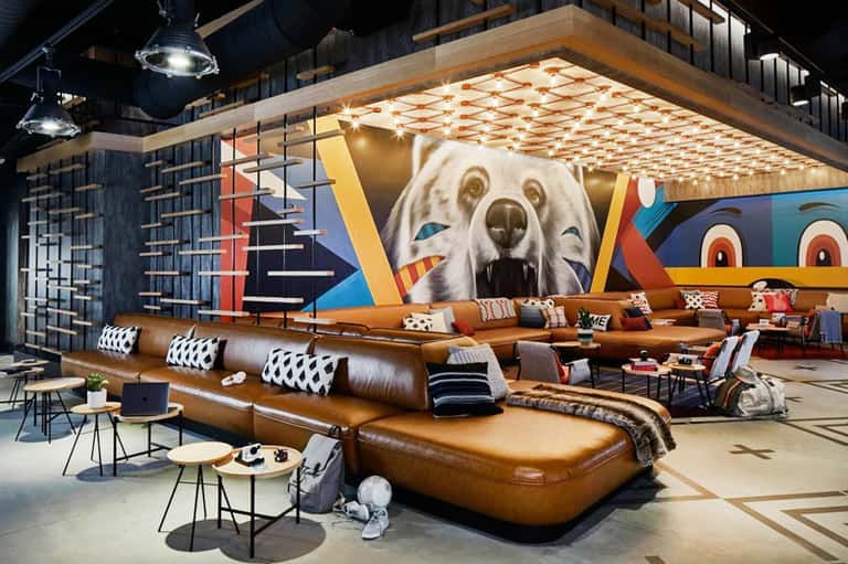 Contemporary hotel lobby with brown leather seating and colorful bear artwork