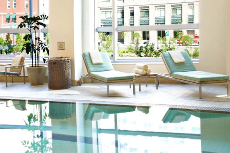 Spa relaxation area with lounge chairs, plants, and ocean view through large windows