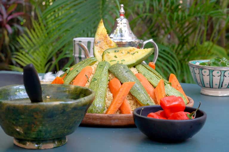 Gourmet appetizer platter with grilled vegetables, herbs, and Moroccan tea service