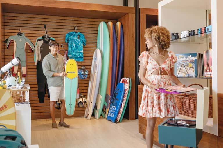 Retail shop interior with wetsuits, surfboards, and beach apparel displayed