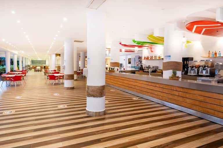 Modern hotel lobby with reception desk, dining area, and contemporary décor with colorful artwork