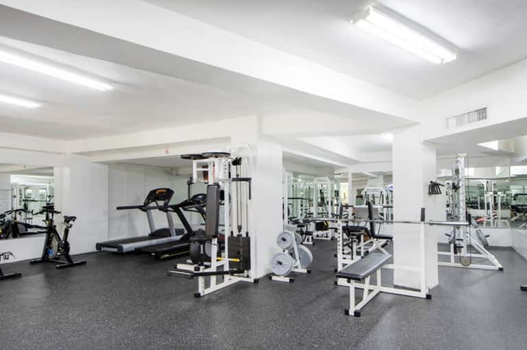 Modern fitness center with treadmills, weight machines, and mirrored walls