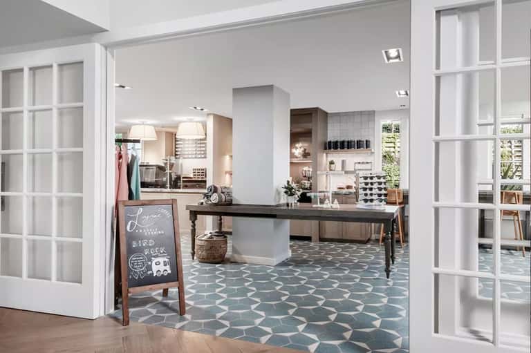 Spa and salon reception area with modern white doors, wooden desk, and geometric floor tiles