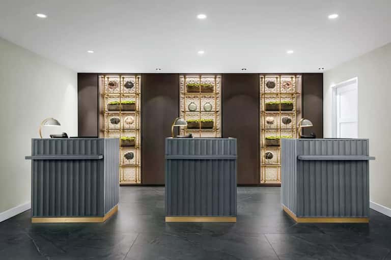 Luxury hotel lobby with three reception desks and decorative plant wall installations