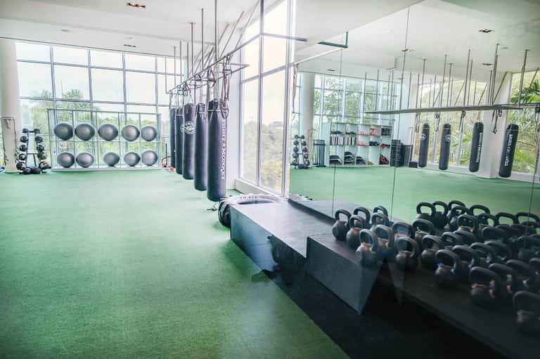 Modern fitness center with exercise equipment, kettlebells, and floor-to-ceiling windows