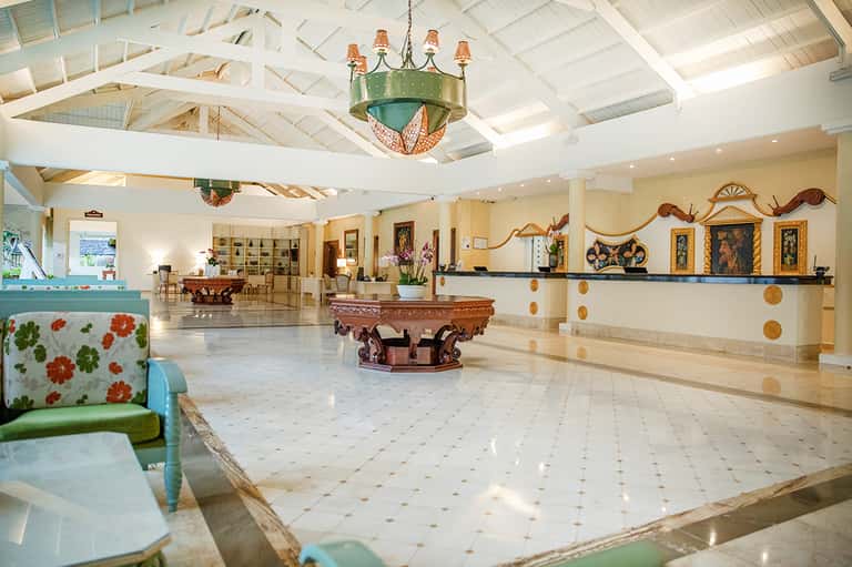 Grand hotel lobby with vaulted white ceiling, decorative chandelier, pool tables, and ornate furnishings